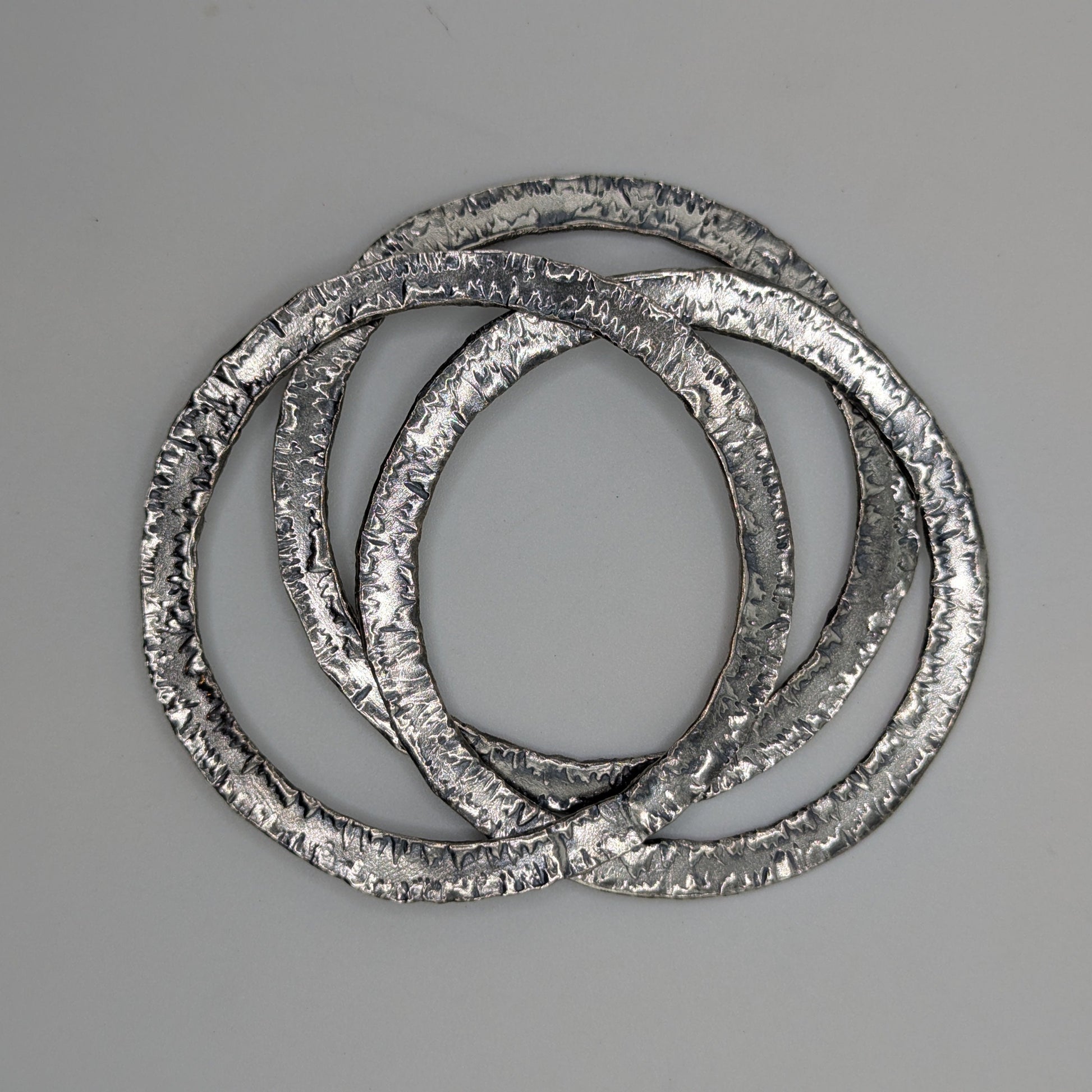 Three metallic rings stacked on a gray background