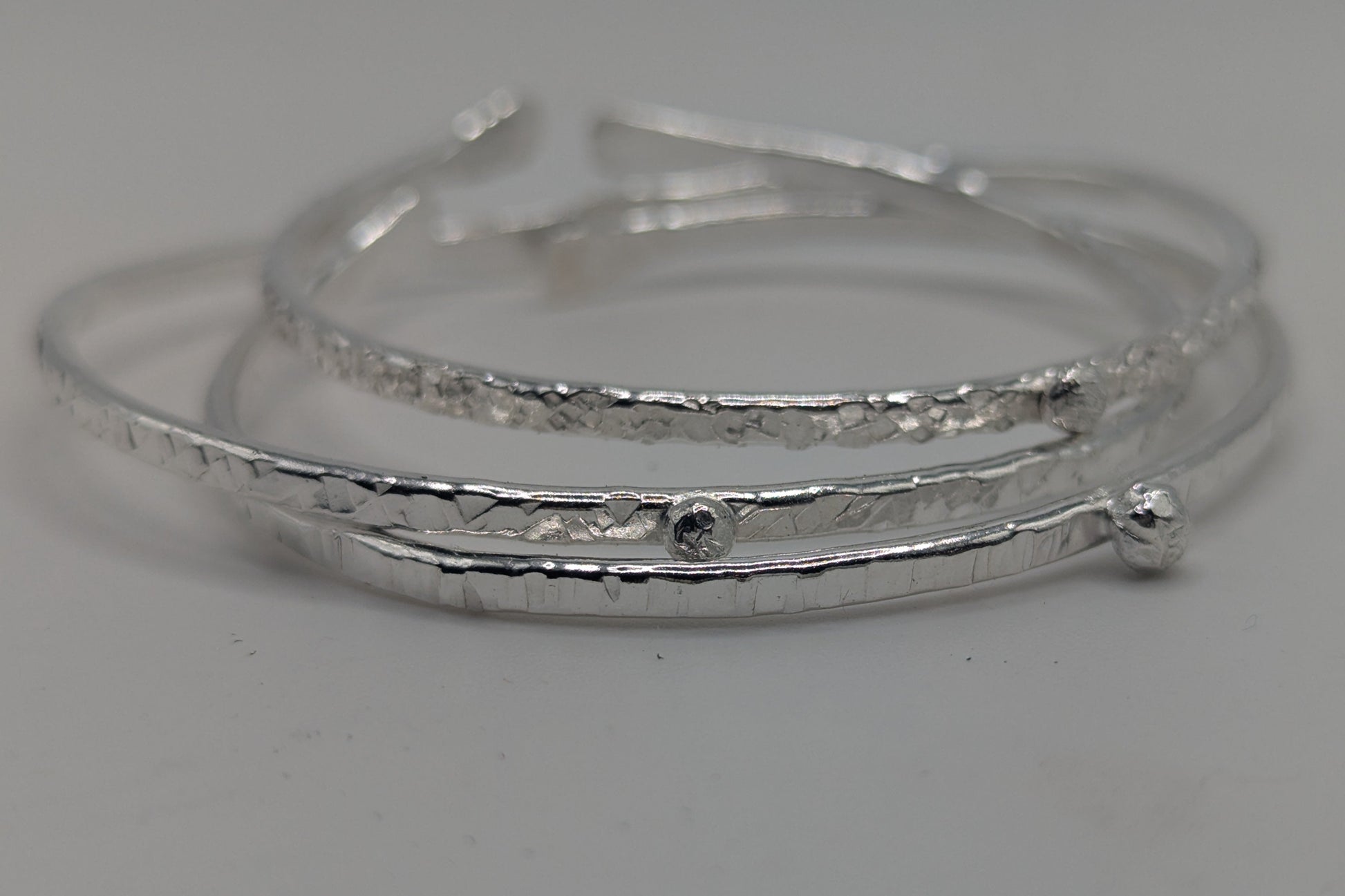 Silver bangle on a light gray background